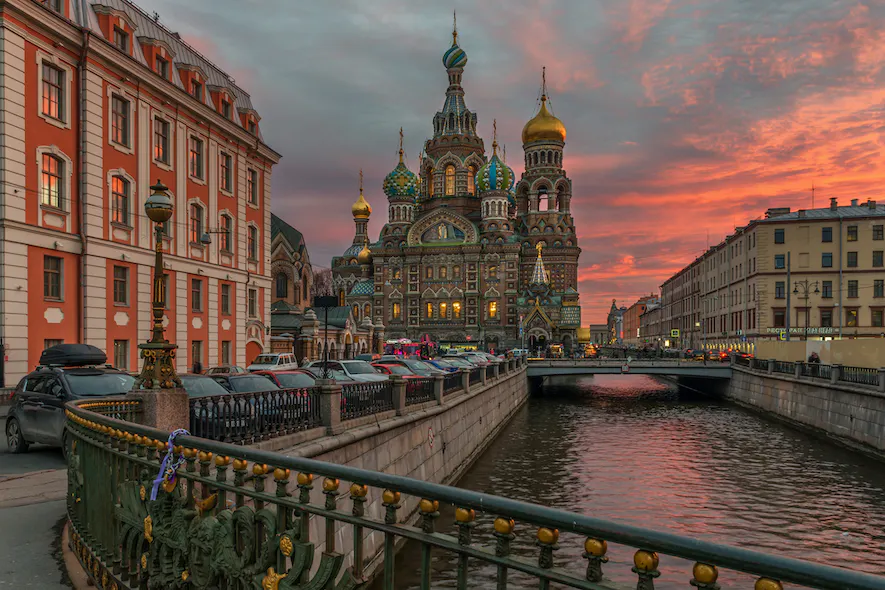The Church of the Savior on Spilled Blood in St. Petersburg, Russia, beside a canal at sunset.