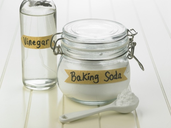 Jar labeled Baking Soda next to a bottle labeled Vinegar and a spoonful of powder