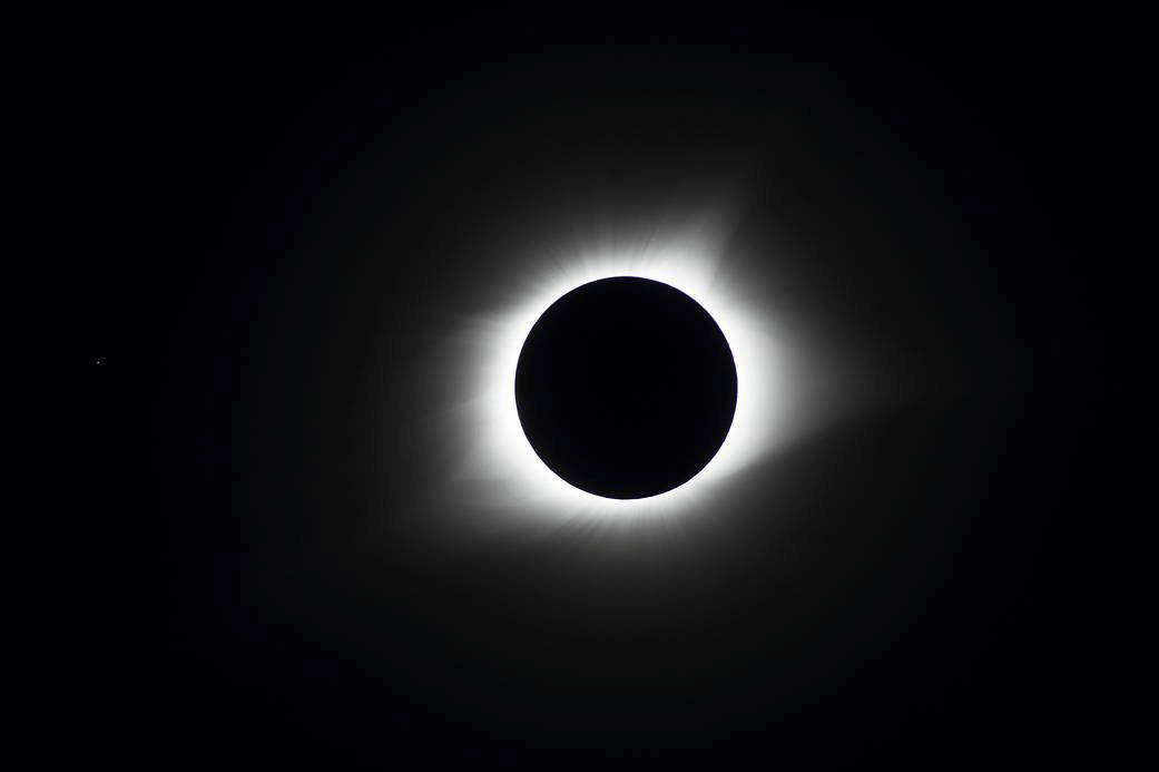Photograph of a total solar eclipse showing the Sun’s corona around the dark Moon.