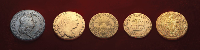 A row of old gold and silver coins from different countries.